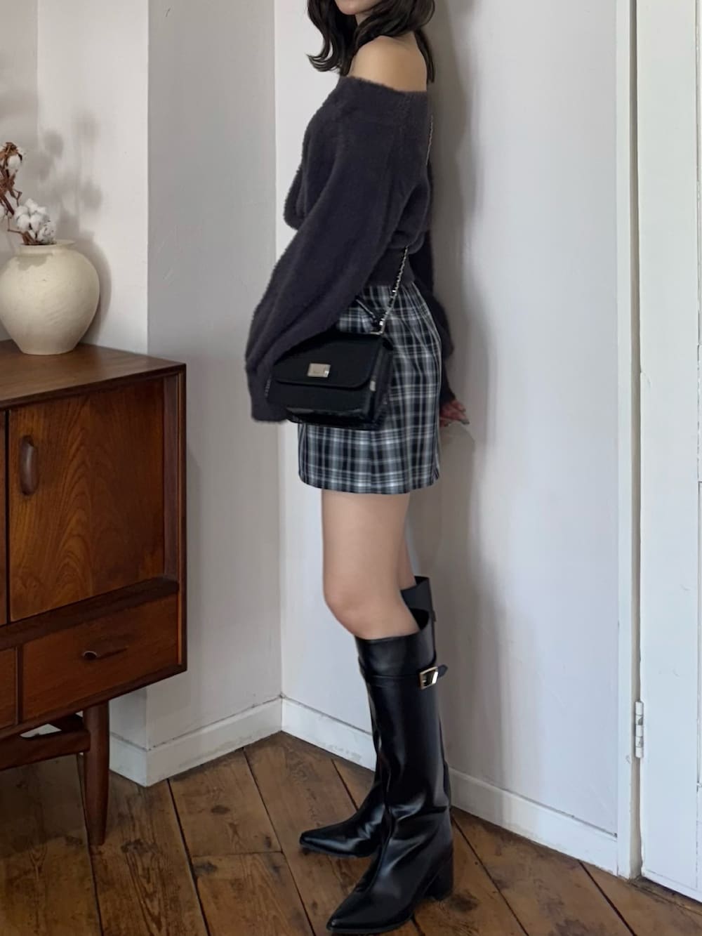 グレー系のニット/セーター、グリーン系のスカート、ブラック系のハンドバッグを着用したレディースの秋コーディネートの6枚目の写真