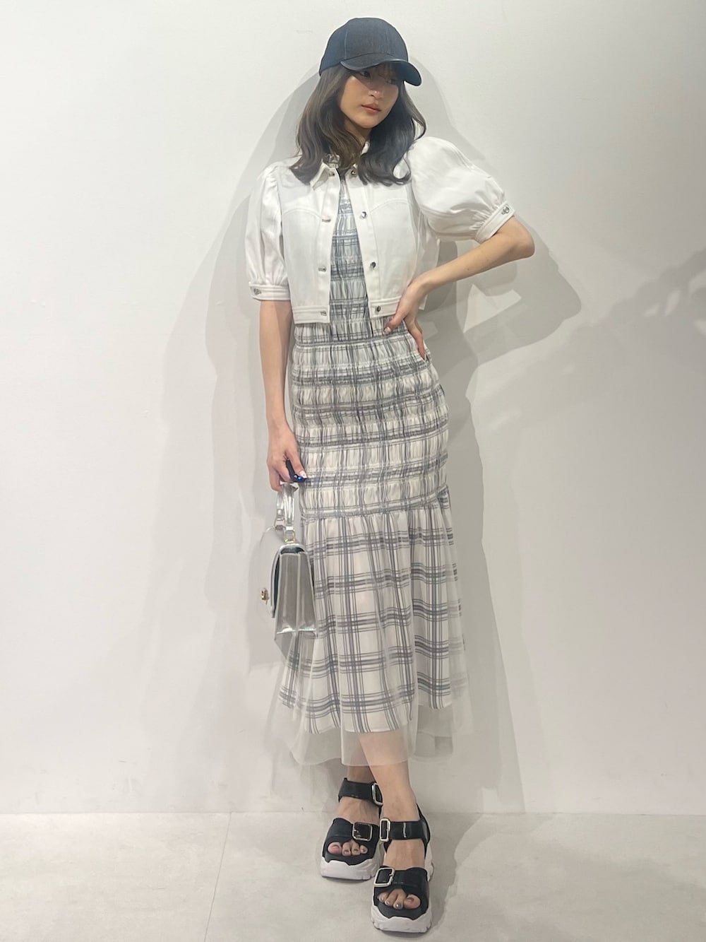 ブラック系のサンダル、ホワイト系のデニムジャケット、ホワイト系のワンピースを着用したレディースの春コーディネートの4枚目の写真