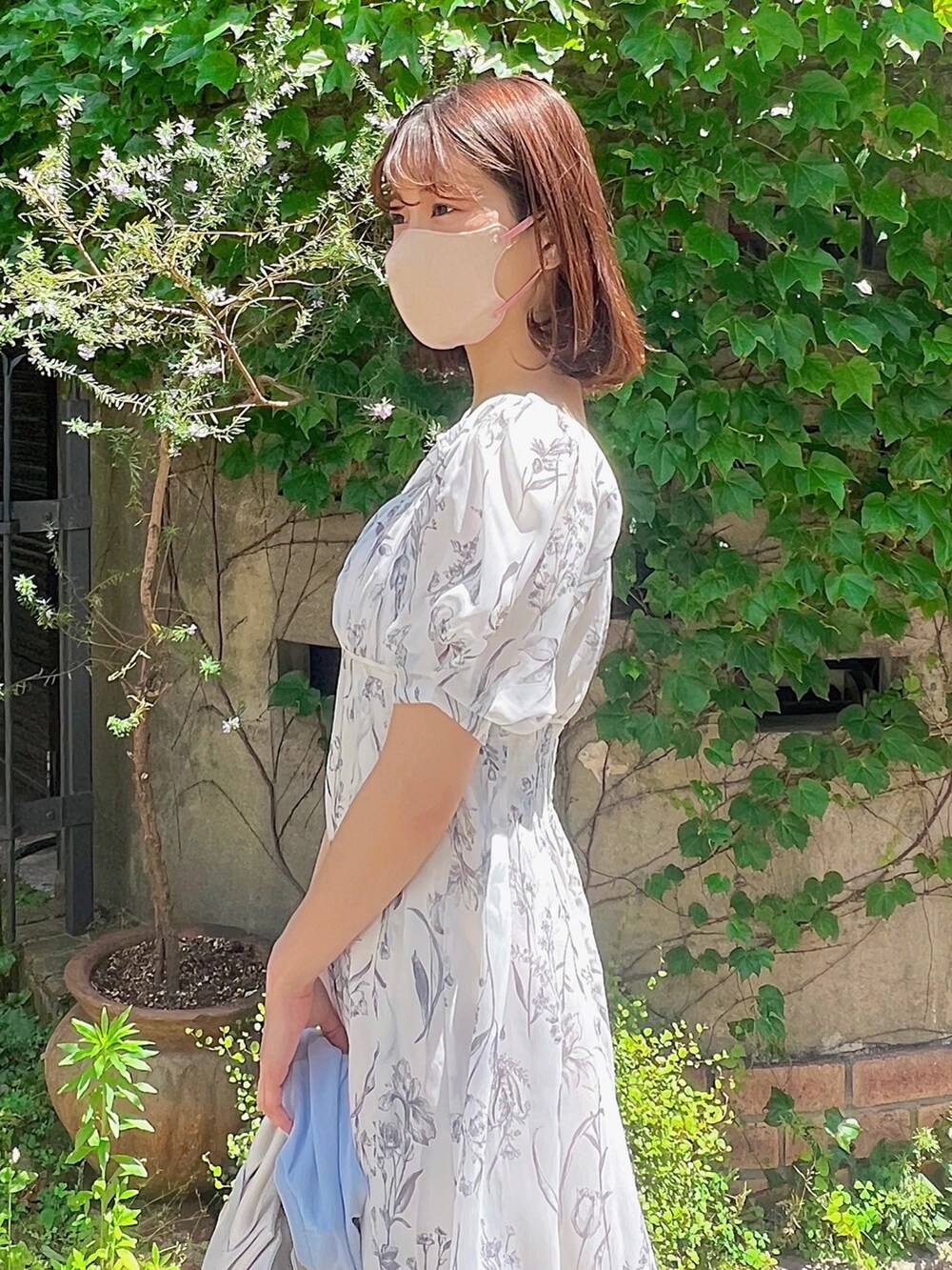 ホワイト系のワンピース、ブルー系のカーディガン/ボレロ、その他のサンダルを着用したレディースの春コーディネートの6枚目の写真