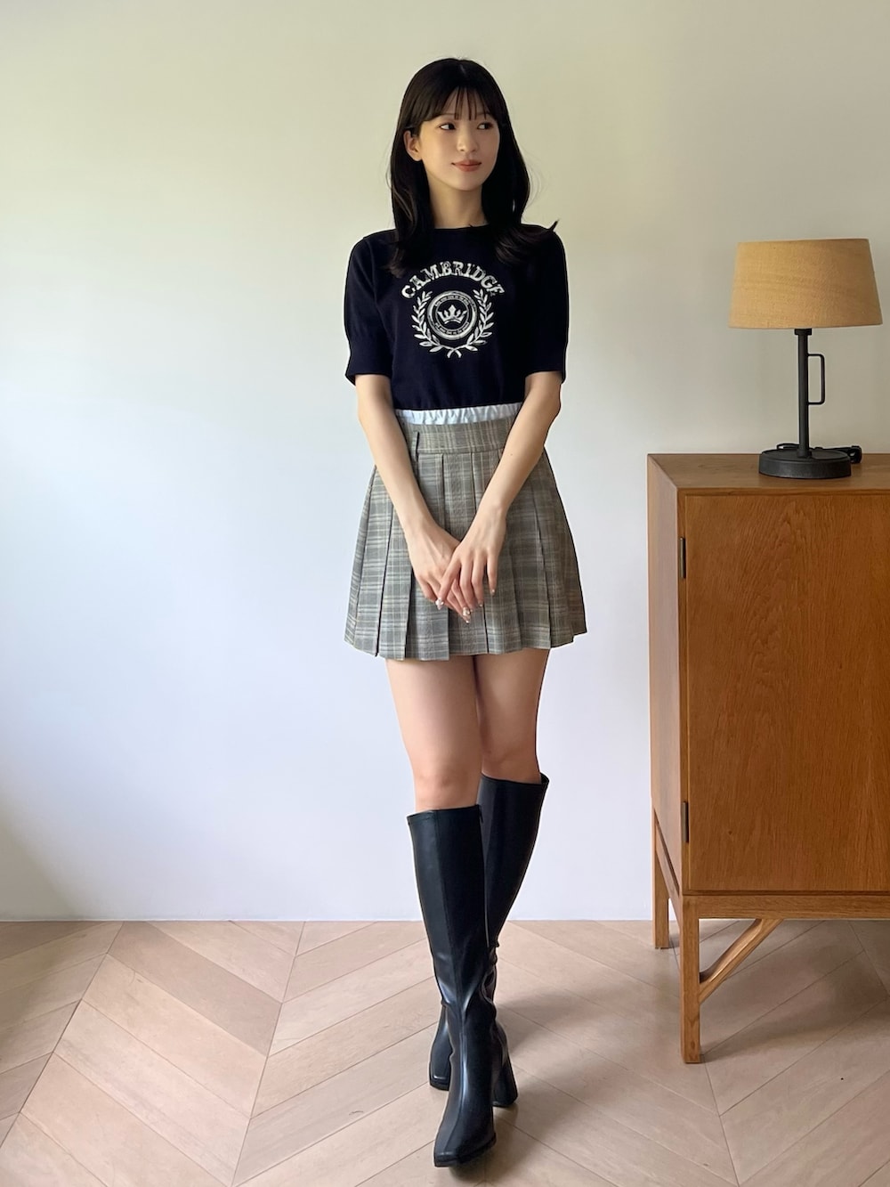 ブルー系のニット/セーター、グレー系のスカート、ブラック系のブーツを着用したレディースの夏コーディネートの5枚目の写真