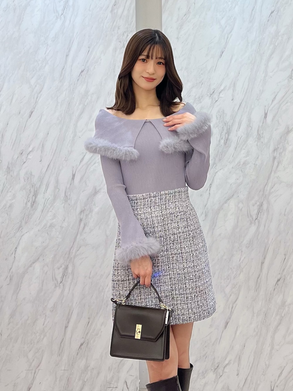 ブラウン系のブーツ、ブラウン系のハンドバッグ、ホワイト系のスカートを着用したレディースの冬コーディネートの4枚目の写真