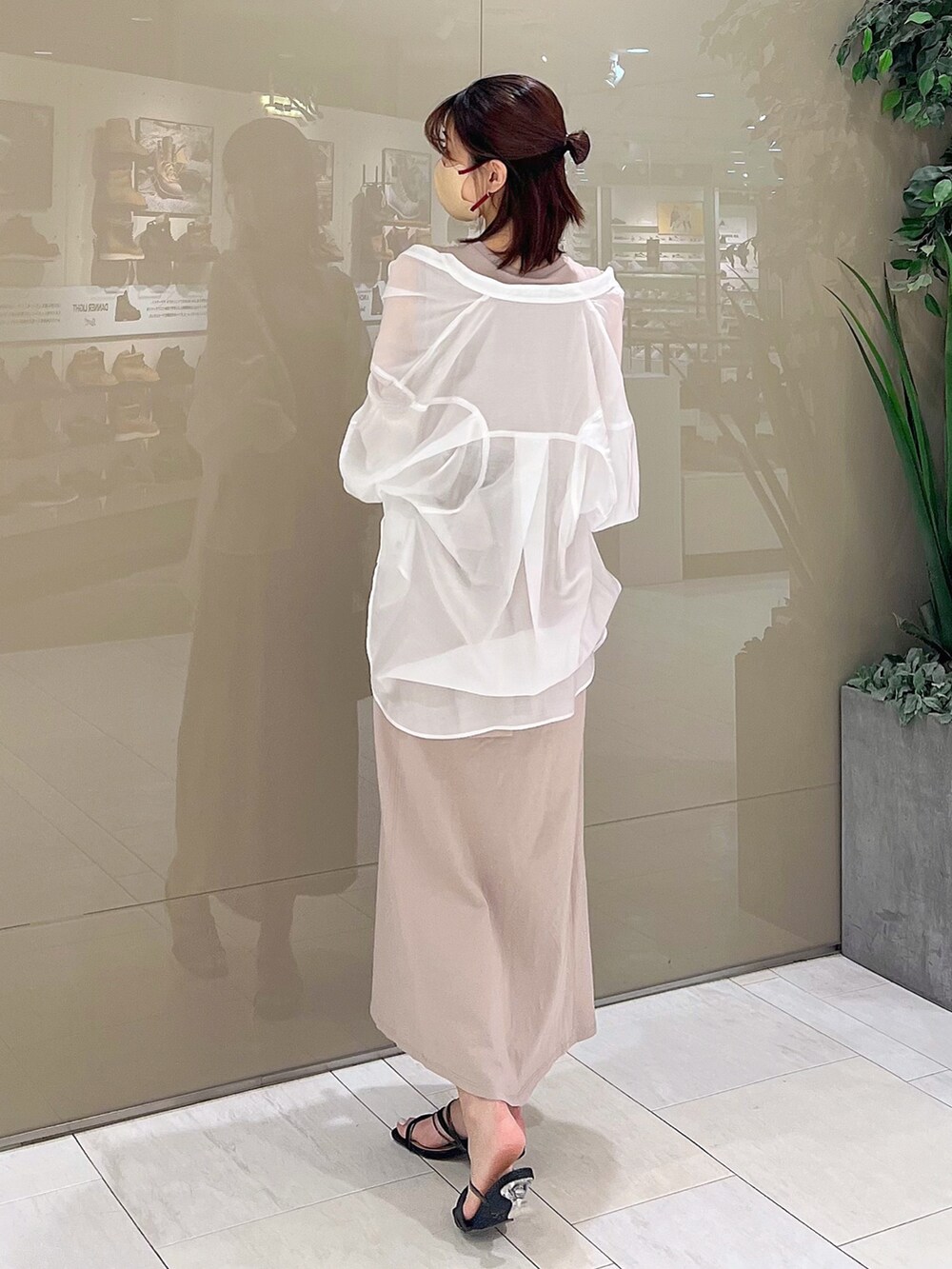 ベージュ系のワンピース、ブラック系のハンドバッグ、ブラック系のサンダルを着用したレディースの春コーディネートの4枚目の写真