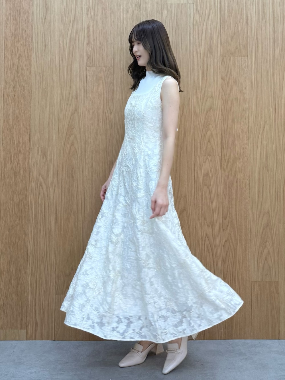 ホワイト系のワンピース、ホワイト系のニット/セーター、ホワイト系のパンプスを着用したレディースの冬コーディネートの2枚目の写真