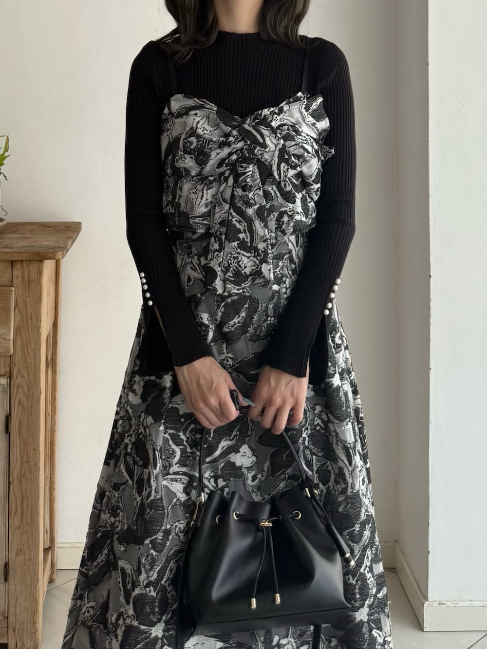 ブラック系のニット/セーター、ブラック系のワンピース、レッド系のブーツを着用したレディースの秋コーディネートの2枚目の写真