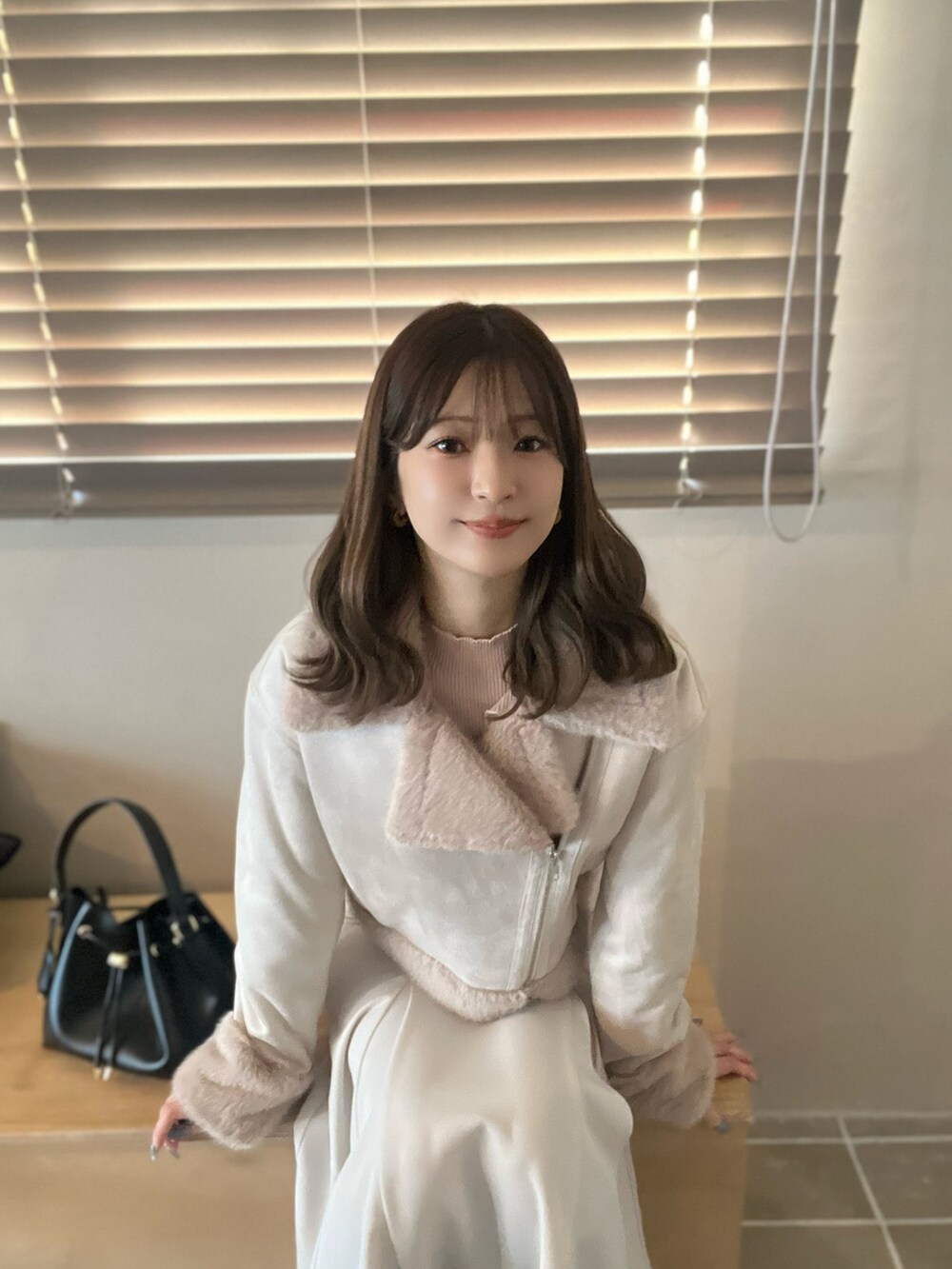 ホワイト系のスカート、ベージュ系のニット/セーターを着用したレディースの秋コーディネートの10枚目の写真