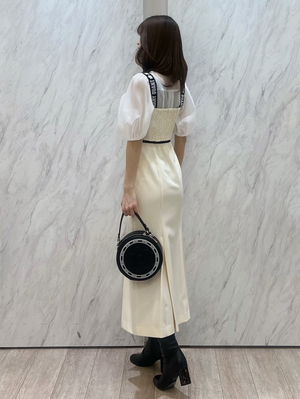 ホワイト系のシャツ/ブラウス、ホワイト系のスカート、ブラック系のショルダーバッグを着用したレディースの冬コーディネートの4枚目の写真