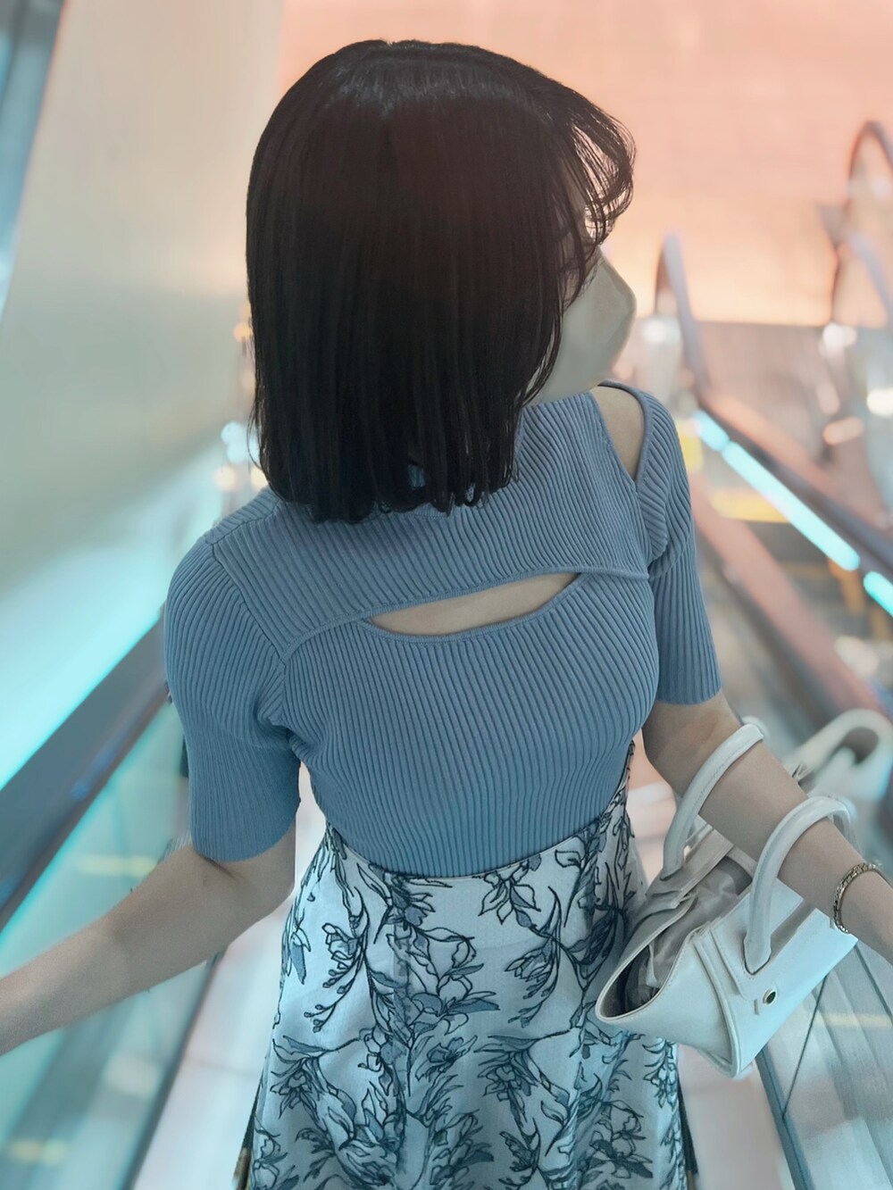 グレー系のスカート、ブルー系のニット/セーター、ホワイト系のトートバッグを着用したレディースの春コーディネートの4枚目の写真