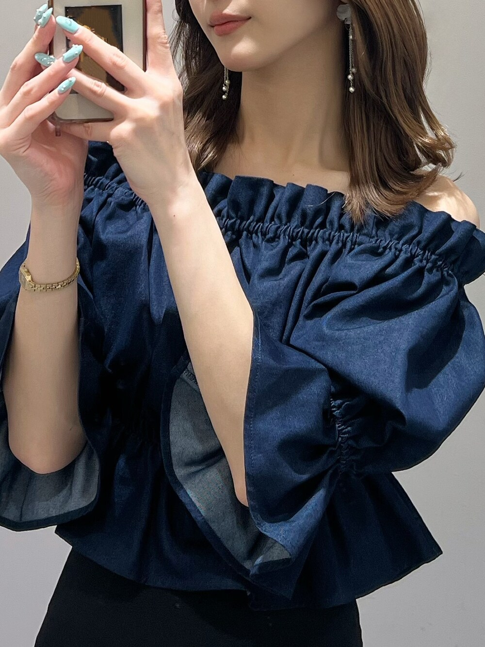 ブルー系のシャツ/ブラウス、ブラック系のショルダーバッグ、ブルー系のスカートを着用したレディースの春コーディネートの2枚目の写真