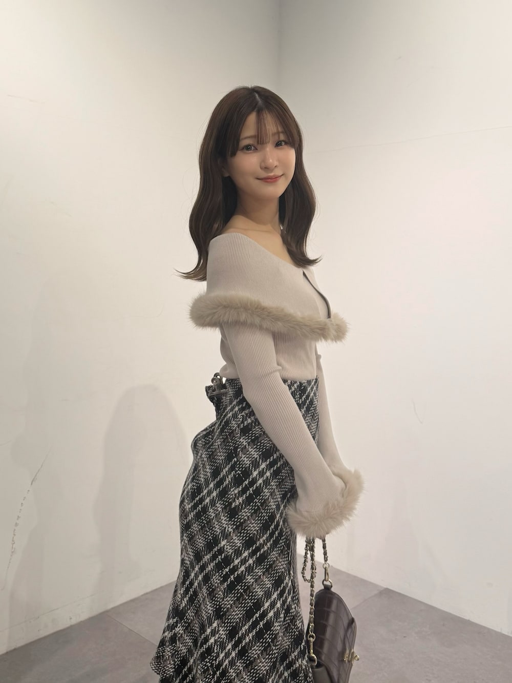 ベージュ系のニット/セーター、ブラック系のスカート、ブラウン系のブーツを着用したレディースの冬コーディネートの3枚目の写真