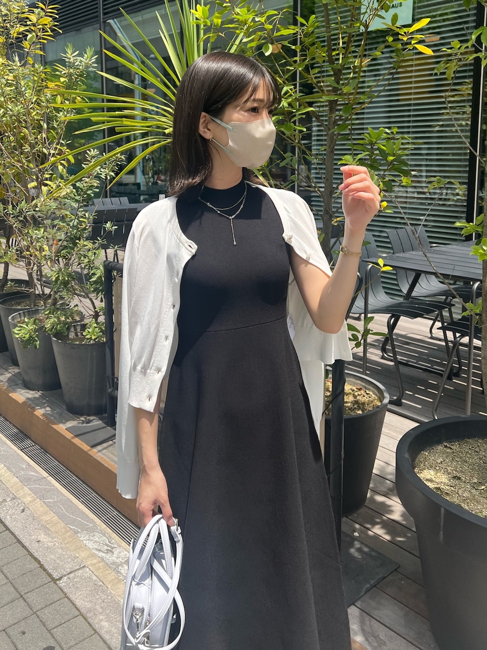 ブラック系のワンピース、ホワイト系のカーディガン/ボレロ、ブルー系のハンドバッグを着用したレディースの春コーディネートの9枚目の写真