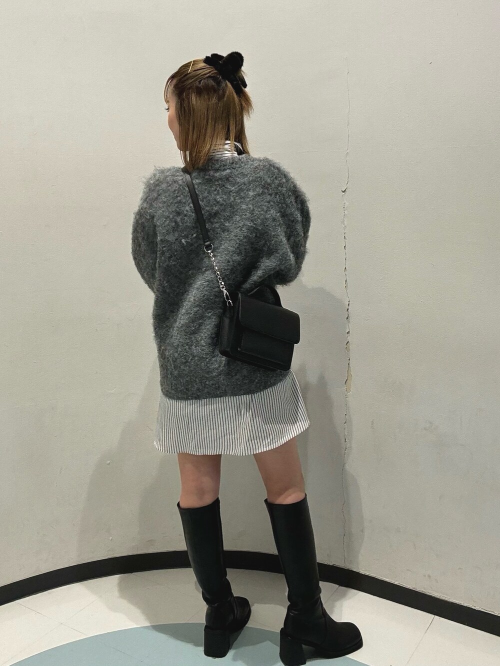 ブラック系のハンドバッグ、グレー系のニット/セーター、ブラック系のブーツを着用したレディースの秋コーディネートの5枚目の写真