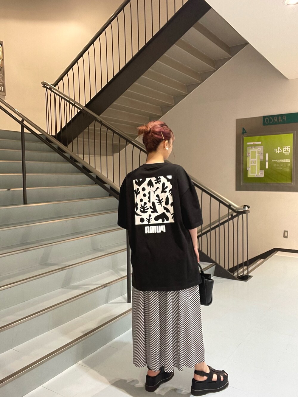 ブラック系のショルダーバッグ、ブラック系のTシャツ/カットソー、ブラック系のサンダルを着用したレディースの春コーディネートの3枚目の写真