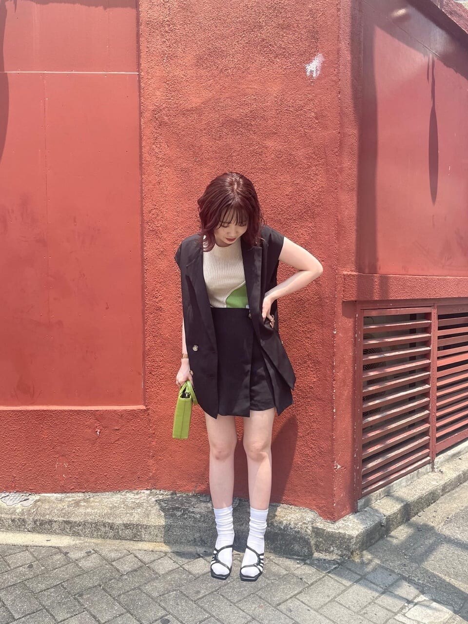 ブラック系のベスト、ブラック系のスラックス、ブラック系のサンダルを着用したレディースの夏コーディネートの2枚目の写真