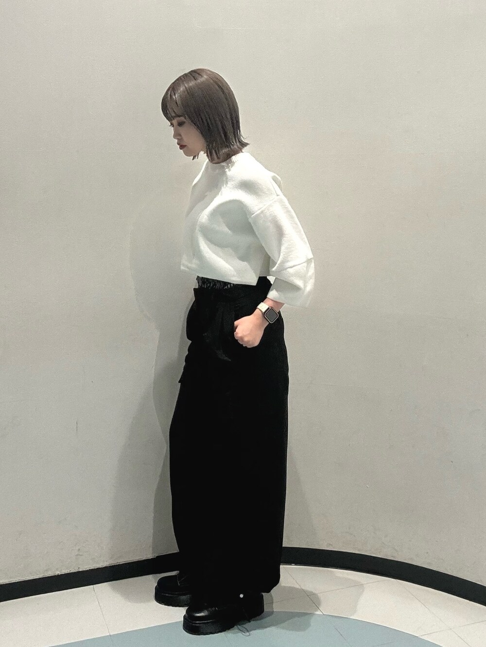 ブルー系のニット/セーター、ブラック系のその他パンツ、ブラック系のブーツを着用したレディースの冬コーディネートの3枚目の写真