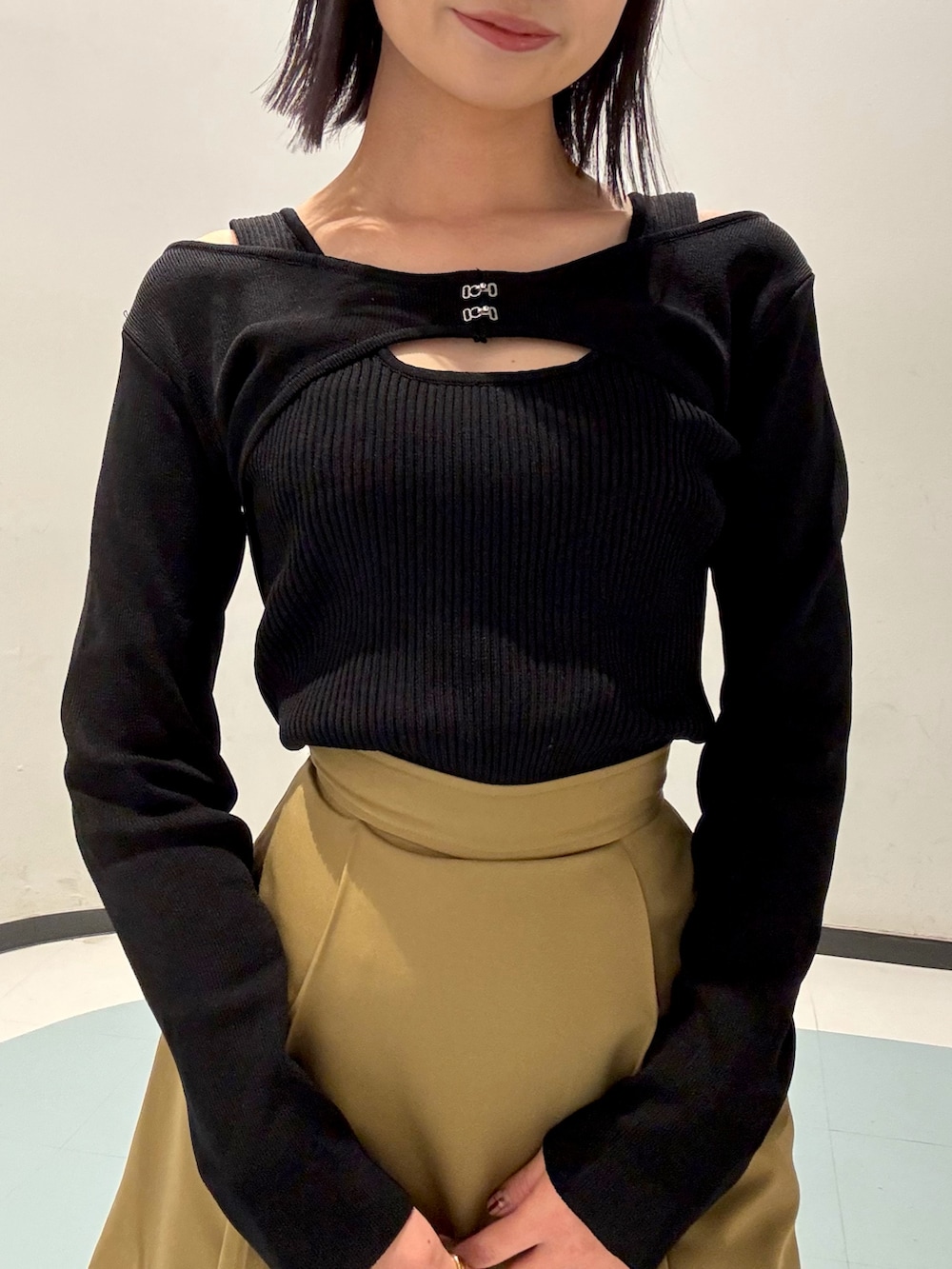 ブラック系のショルダーバッグ、ベージュ系のスカート、ベージュ系のブルゾンを着用したレディースの春コーディネートの5枚目の写真