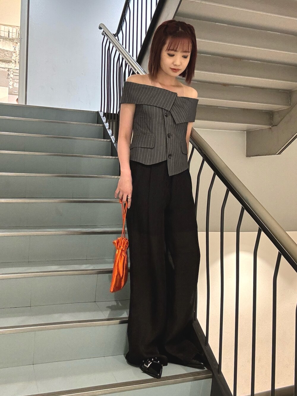 オレンジ系のショルダーバッグ、ブラック系のパンプス、ブラック系のその他パンツを着用したレディースの夏コーディネートの4枚目の写真