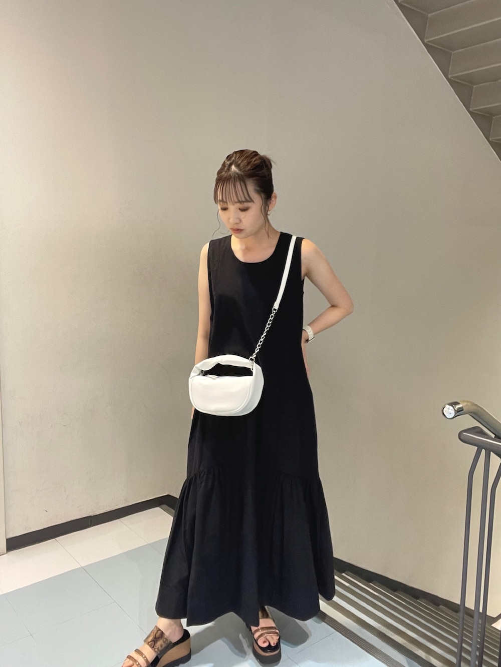 ブルー系のシャツ/ブラウス、ホワイト系のハンドバッグ、ブラック系のサンダルを着用したレディースの夏コーディネートの3枚目の写真