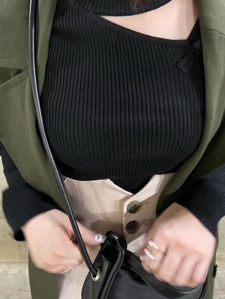 ブラック系のニット/セーター、ホワイト系のワンピース、ベージュ系のトレンチコートを着用したレディースの秋コーディネートの2枚目の写真