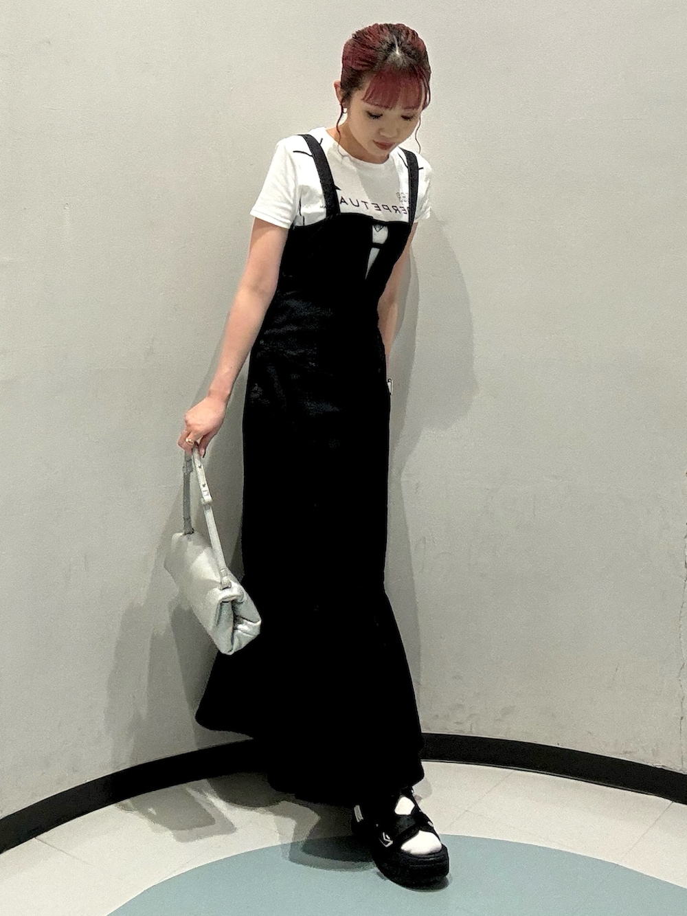 ブラック系のワンピース、ブラック系のサンダル、ホワイト系のTシャツ/カットソーを着用したレディースの夏コーディネートの2枚目の写真