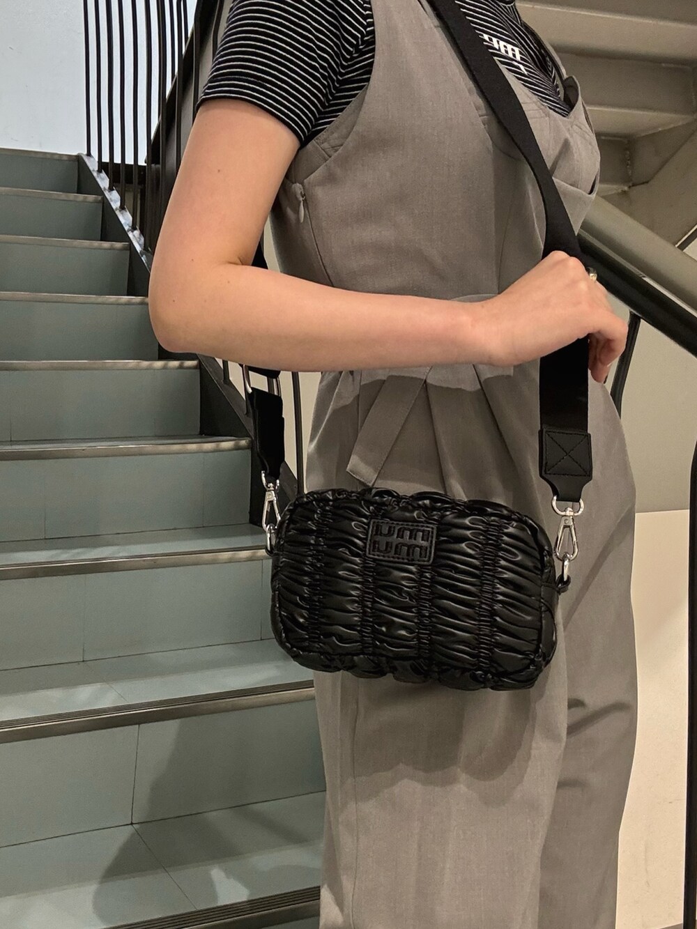 グレー系のワンピース、ブラック系のショルダーバッグ、シルバー系のサンダルを着用したレディースの春コーディネートの6枚目の写真