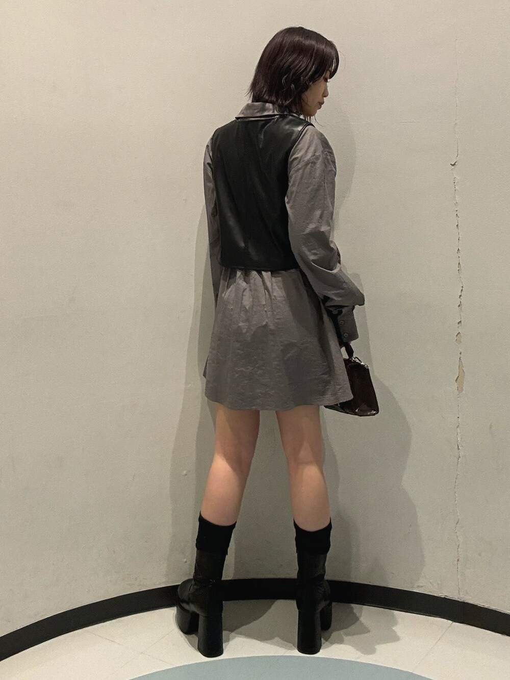 ブラック系のブーツ、グレー系のワンピースを着用したレディースの秋コーディネートの3枚目の写真