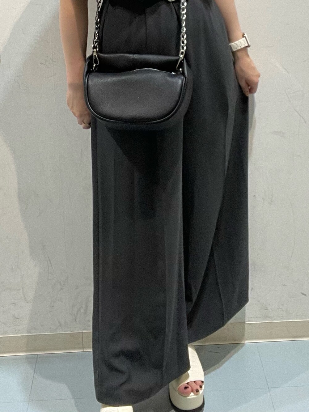 ブラック系のハンドバッグ、ホワイト系のつなぎ/オールインワン、ホワイト系のサンダルを着用したレディースの春コーディネートの6枚目の写真