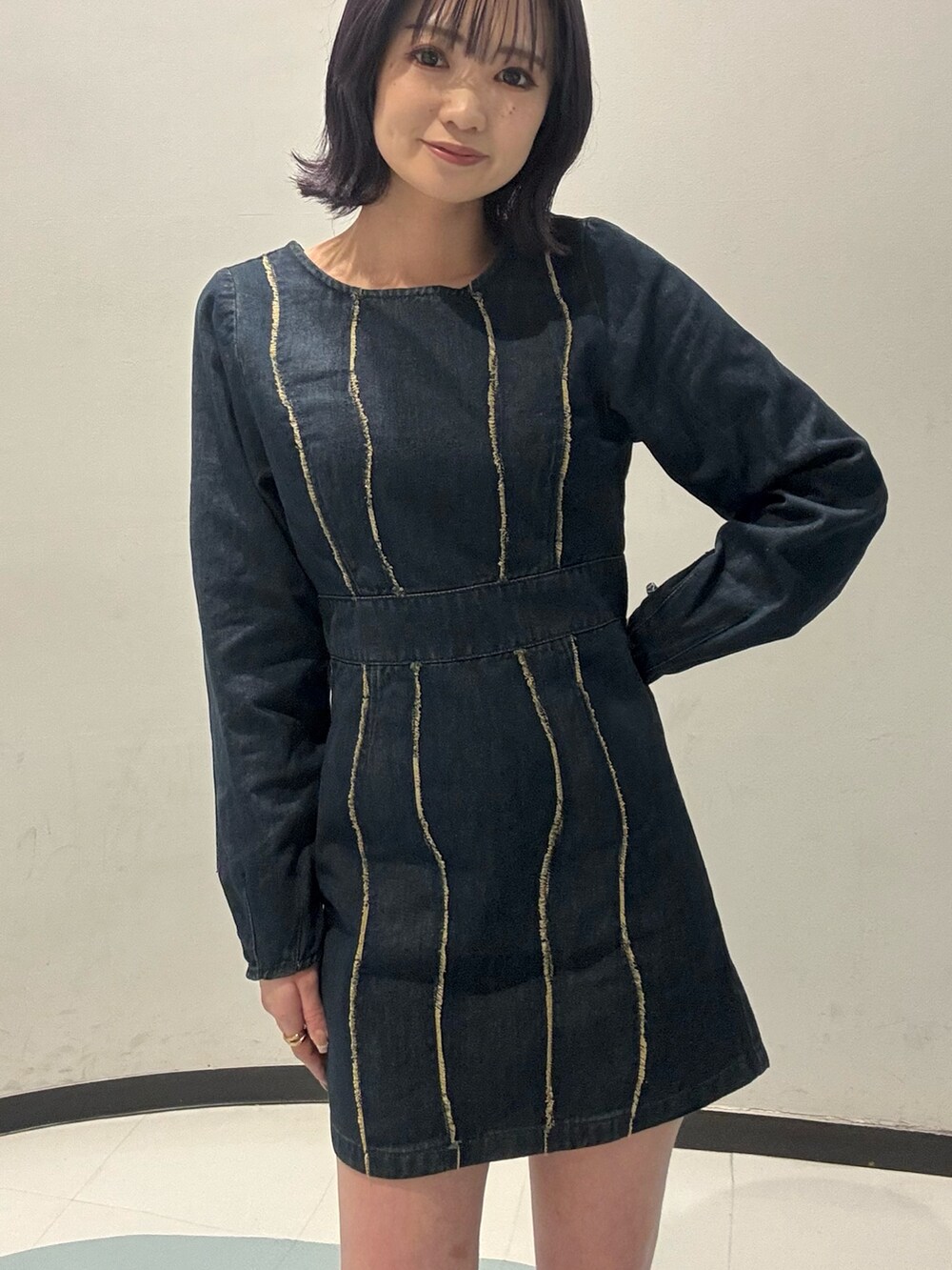 ブラック系のショルダーバッグ、ブラック系のブーツ、ブルー系のワンピースを着用したレディースの冬コーディネートの4枚目の写真