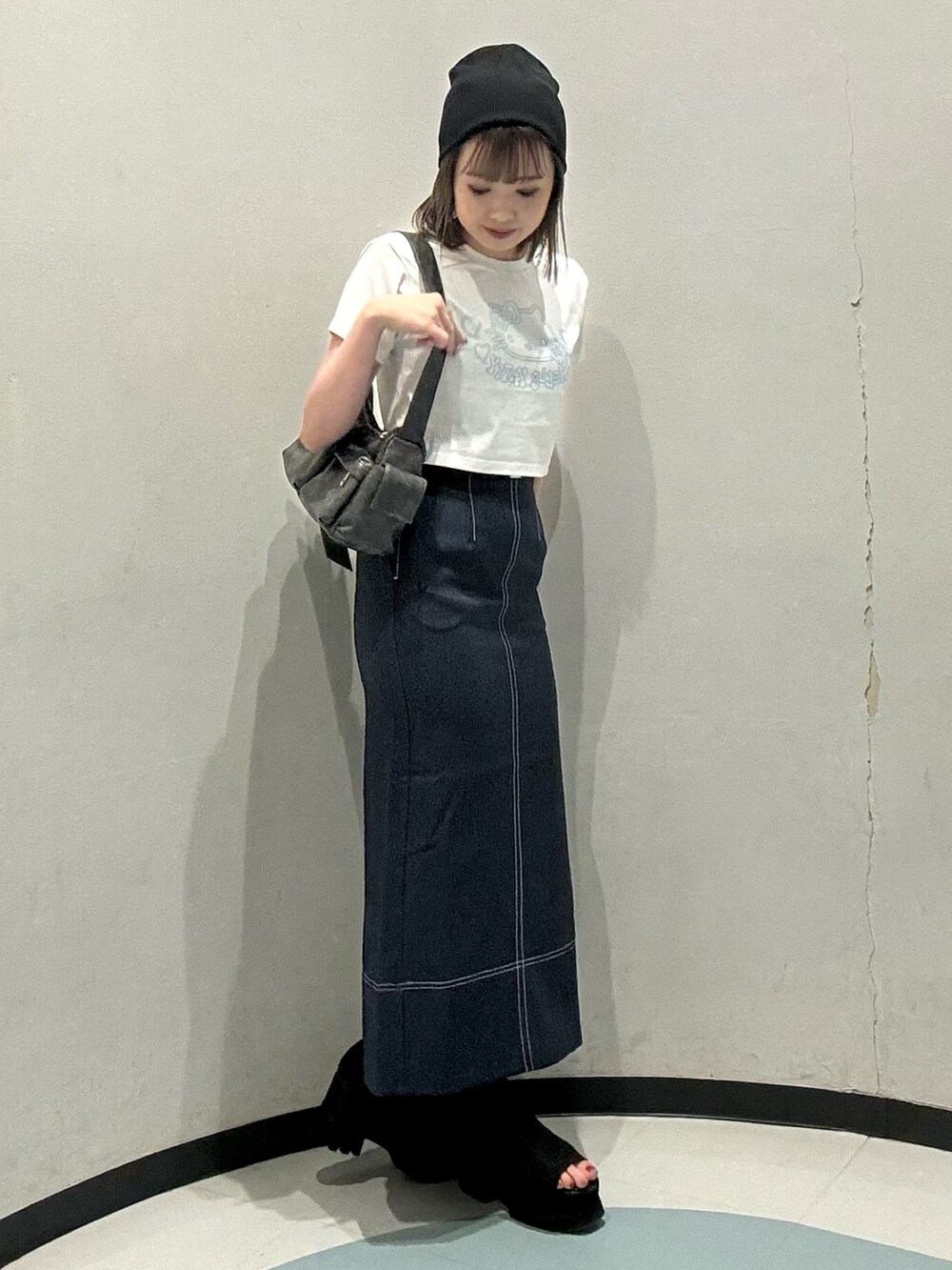 ホワイト系のTシャツ/カットソー、ブルー系のスカート、グレー系のショルダーバッグを着用したレディースの春コーディネートの2枚目の写真