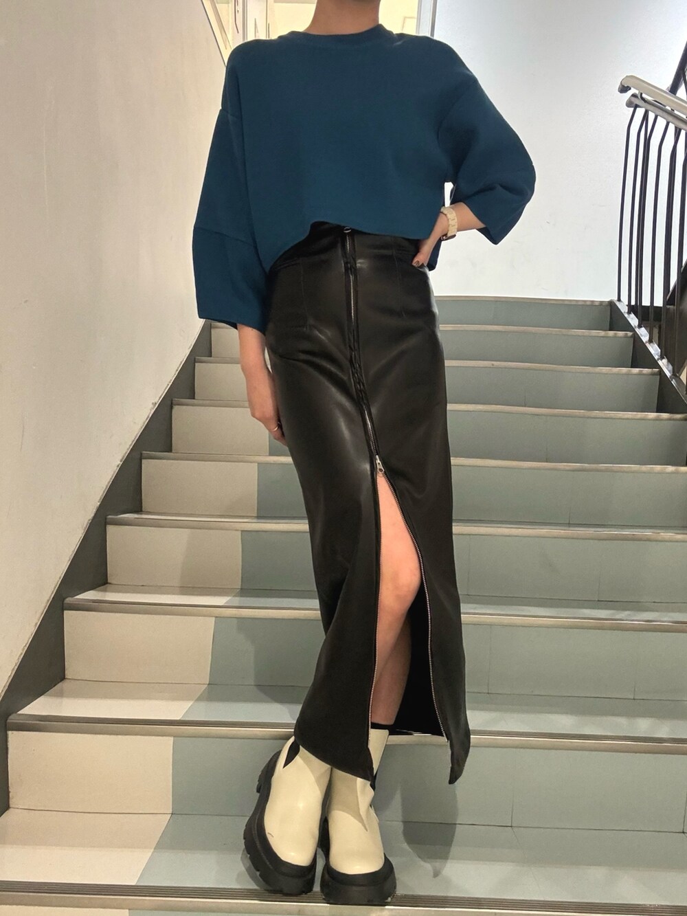 ホワイト系のブーツ、ブラック系のスカート、ブルー系のニット/セーターを着用したレディースの冬コーディネートの4枚目の写真