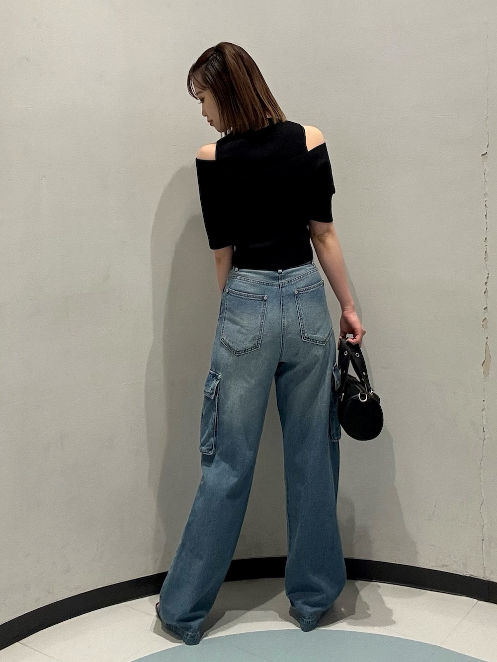 ブラック系のニット/セーター、ブラック系のハンドバッグ、ブラック系のサンダルを着用したレディースの夏コーディネートの3枚目の写真