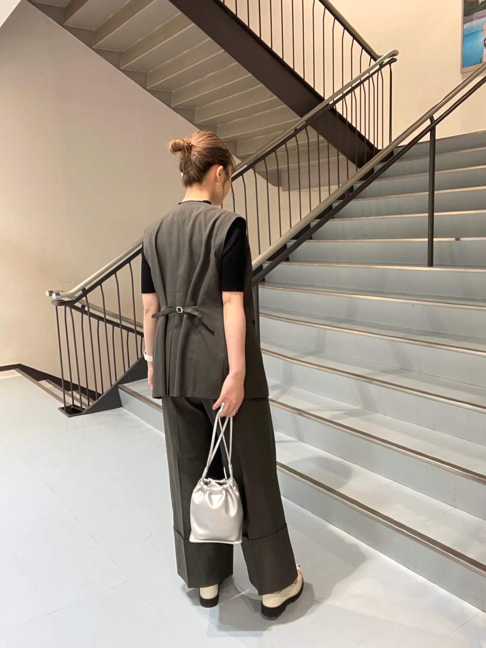 ホワイト系のサンダル、グレー系のスラックス、グレー系のテーラードジャケットを着用したレディースの春コーディネートの2枚目の写真