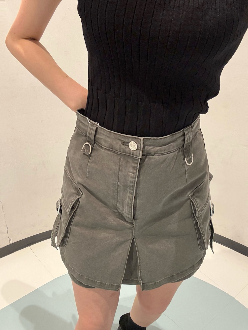 ブラック系のニット/セーター、ブラック系のサンダル、グレー系のスカートを着用したレディースの夏コーディネートの5枚目の写真