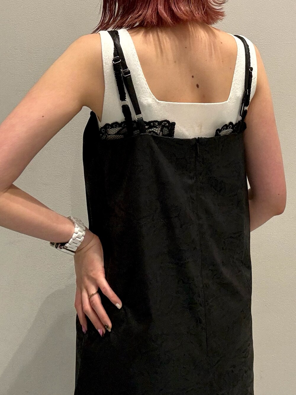 ブラック系のワンピース、ホワイト系のニット/セーター、ブラック系のブーツを着用したレディースの夏コーディネートの6枚目の写真