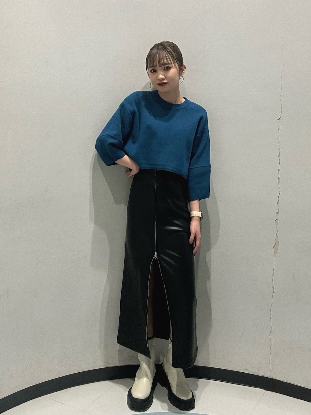 ホワイト系のブーツ、ブラック系のスカート、ブルー系のニット/セーターを着用したレディースの冬コーディネートの3枚目の写真