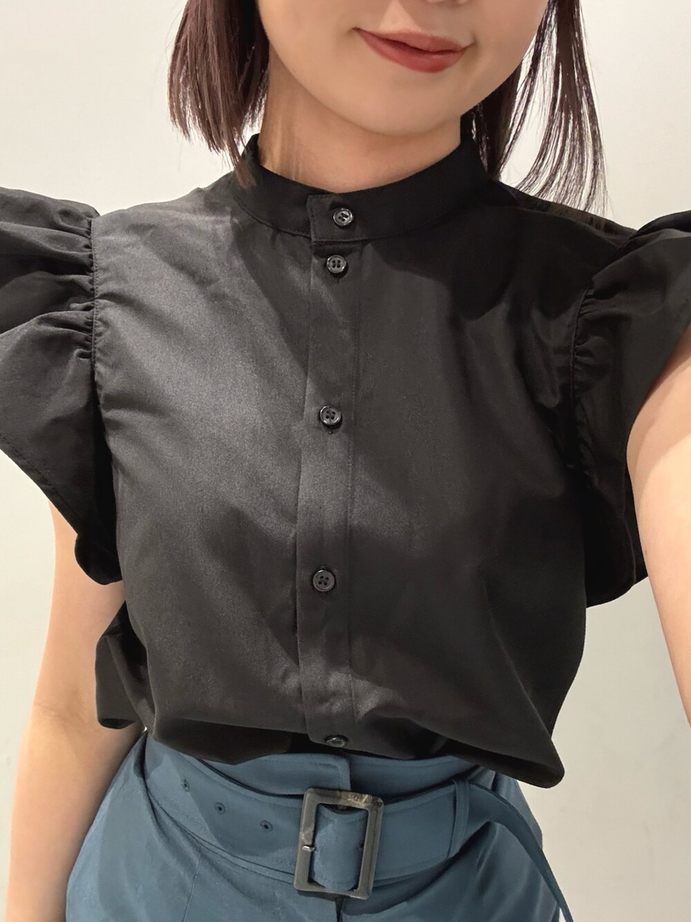 ブラック系のシャツ/ブラウス、ブルー系のスカート、ブラック系のブーツを着用したレディースの春コーディネートの4枚目の写真