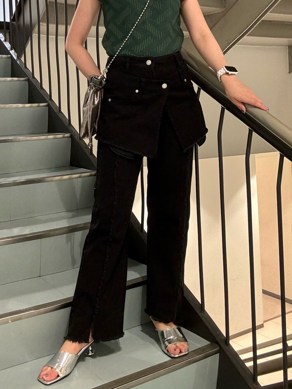 グリーン系のニット/セーター、ブラック系のデニムパンツ、シルバー系のサンダルを着用したレディースの夏コーディネートの6枚目の写真