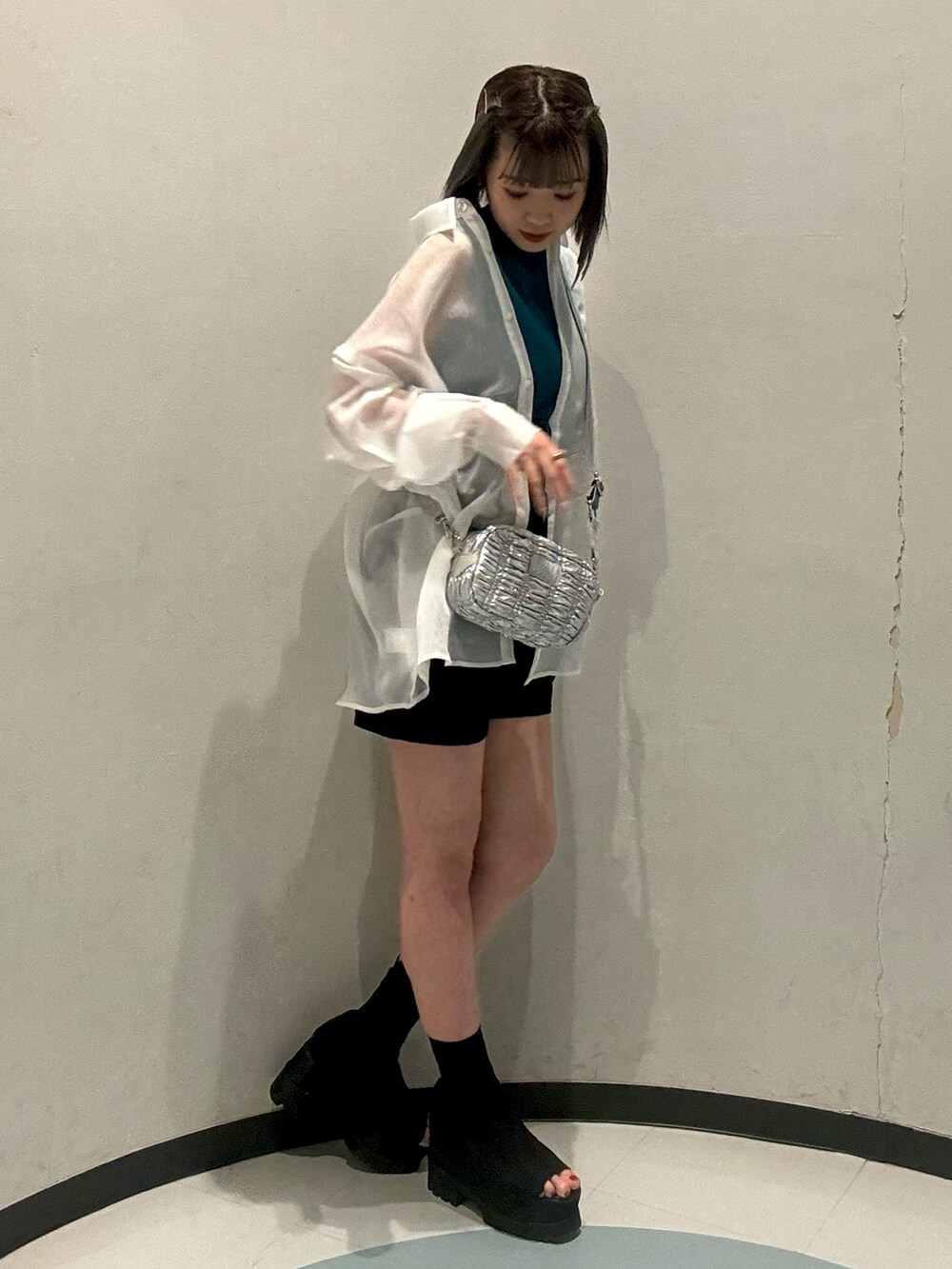 ピンク系のシャツ/ブラウス、ブルー系のニット/セーター、ブラック系のカーゴパンツを着用したレディースの春コーディネートの2枚目の写真