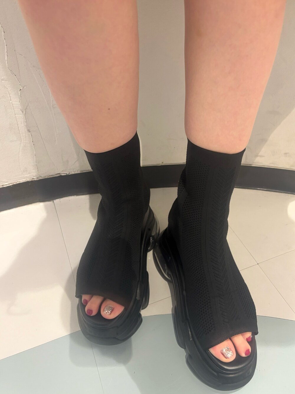 シルバー系のハンドバッグ、ブラック系のサンダル、ブラック系のニット/セーターを着用したレディースの夏コーディネートの7枚目の写真