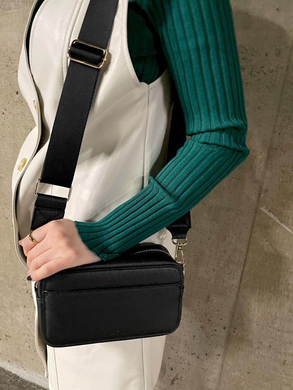 ブラック系のショルダーバッグ、グリーン系のニット/セーター、ホワイト系のワンピースを着用したレディースの冬コーディネートの5枚目の写真