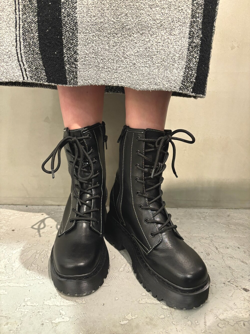 ブラック系のブーツ、シルバー系のハンドバッグ、グレー系のスカートを着用したレディースの冬コーディネートの7枚目の写真