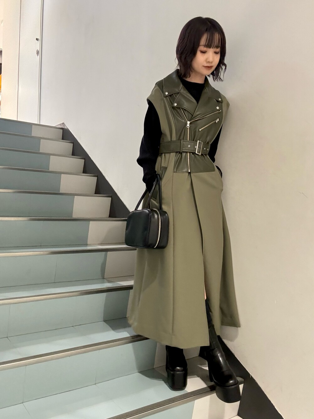 ブラック系のニット/セーター、グリーン系のその他アウター、グレー系のその他パンツを着用したレディースの秋コーディネートの6枚目の写真