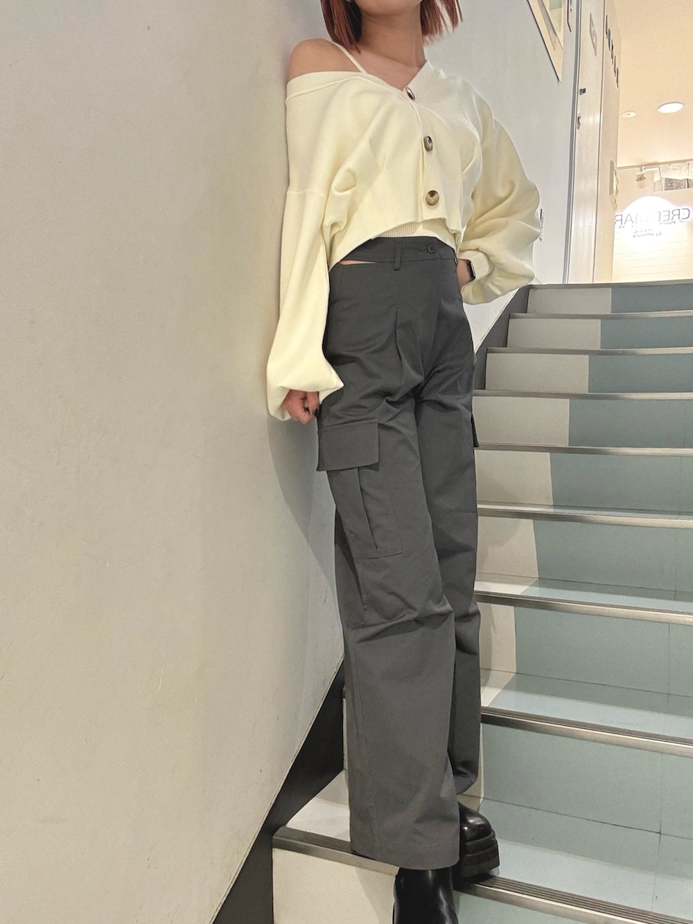 ブラック系のショルダーバッグ、グレー系のカーゴパンツ、ホワイト系のカーディガン/ボレロを着用したレディースの冬コーディネートの6枚目の写真