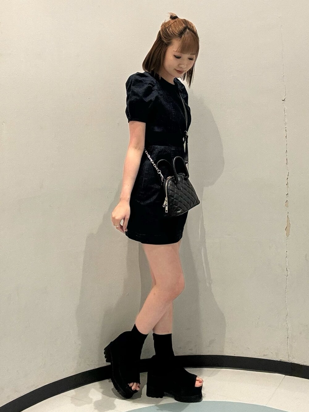 ブルー系のワンピース、ブラック系のブーツを着用したレディースの夏コーディネートの2枚目の写真