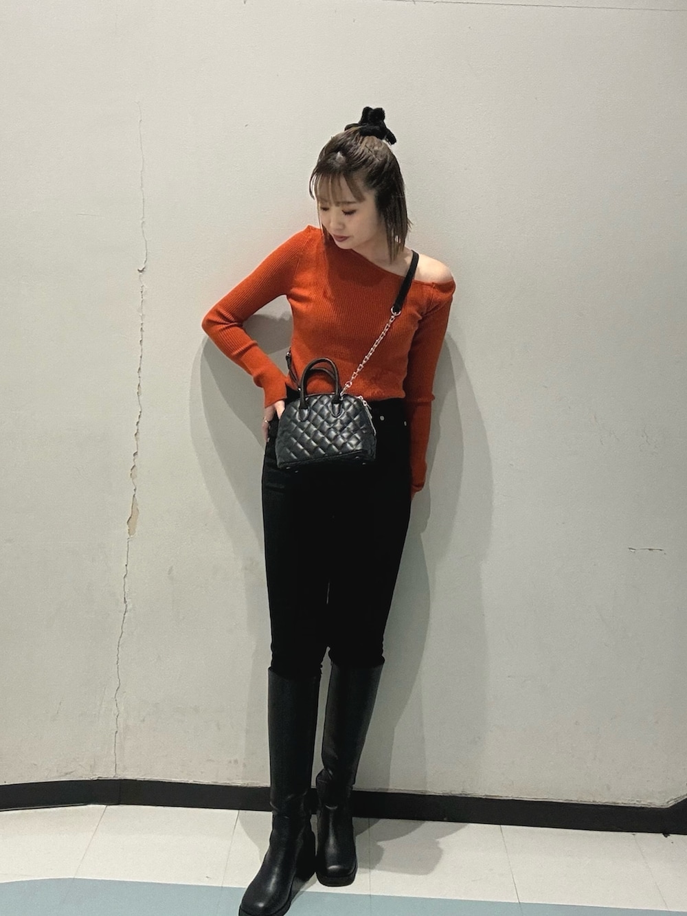 ブラック系のブーツ、ブラック系のハンドバッグ、ブラウン系のムートンコートを着用したレディースの冬コーディネートの4枚目の写真