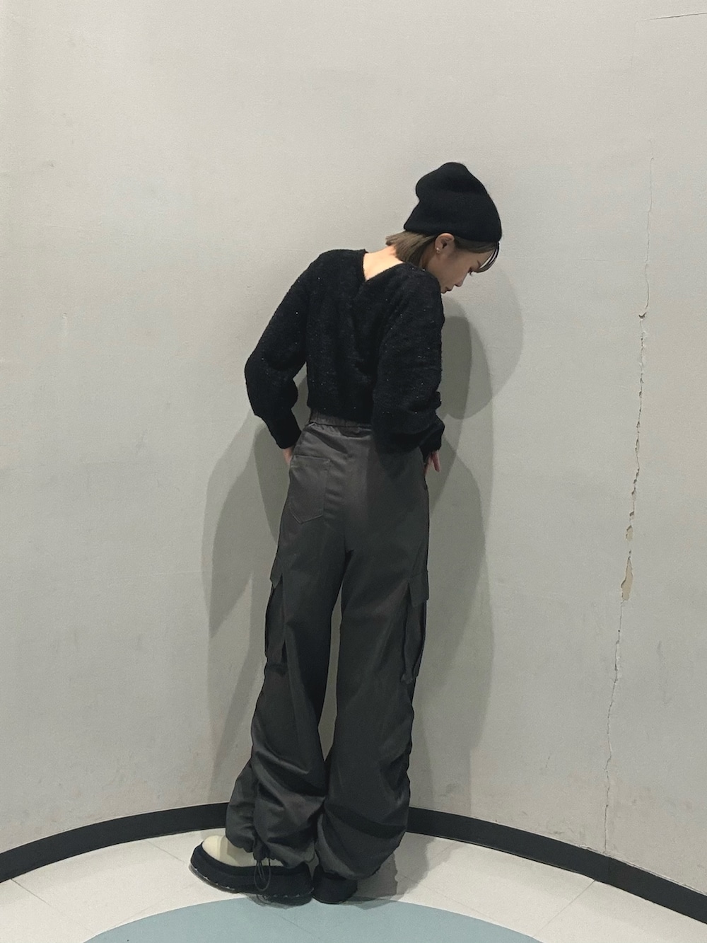 ホワイト系のブーツ、ブラック系のニット/セーター、グレー系のカーゴパンツを着用したレディースの冬コーディネートの4枚目の写真