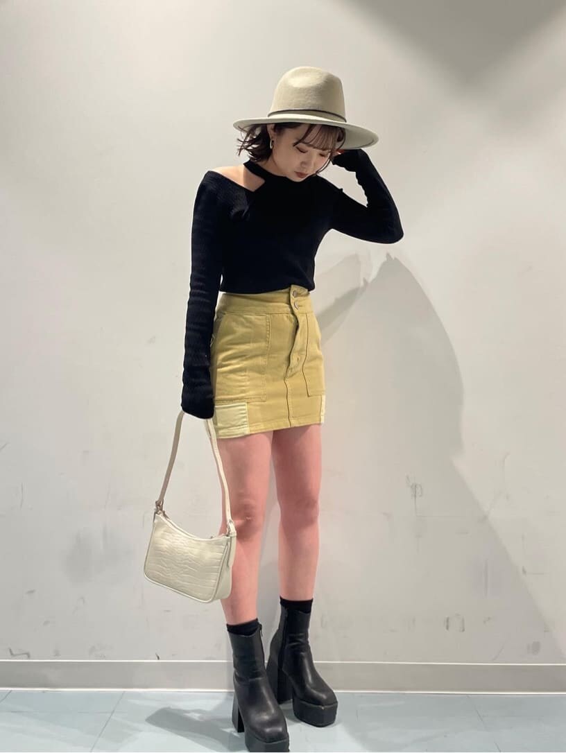 ホワイト系のハンドバッグ、イエロー系のデニムジャケット、イエロー系のスカートを着用したレディースの冬コーディネートの2枚目の写真