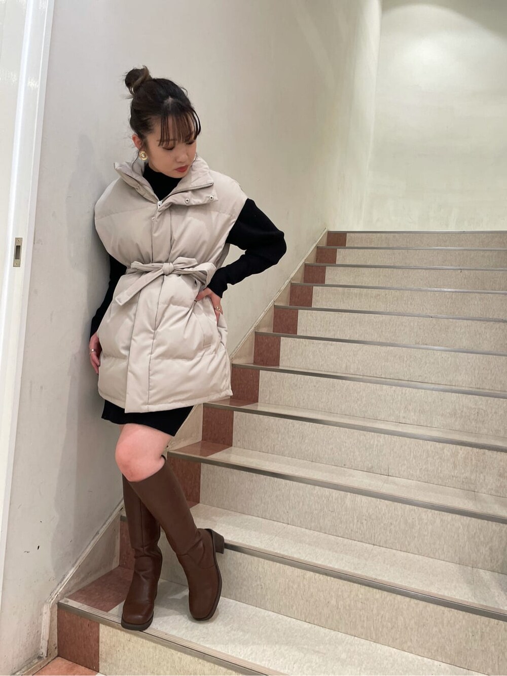ホワイト系のダウンベスト、ベージュ系のショルダーバッグ、ホワイト系のダウンジャケット/コートを着用したレディースの秋コーディネートの5枚目の写真