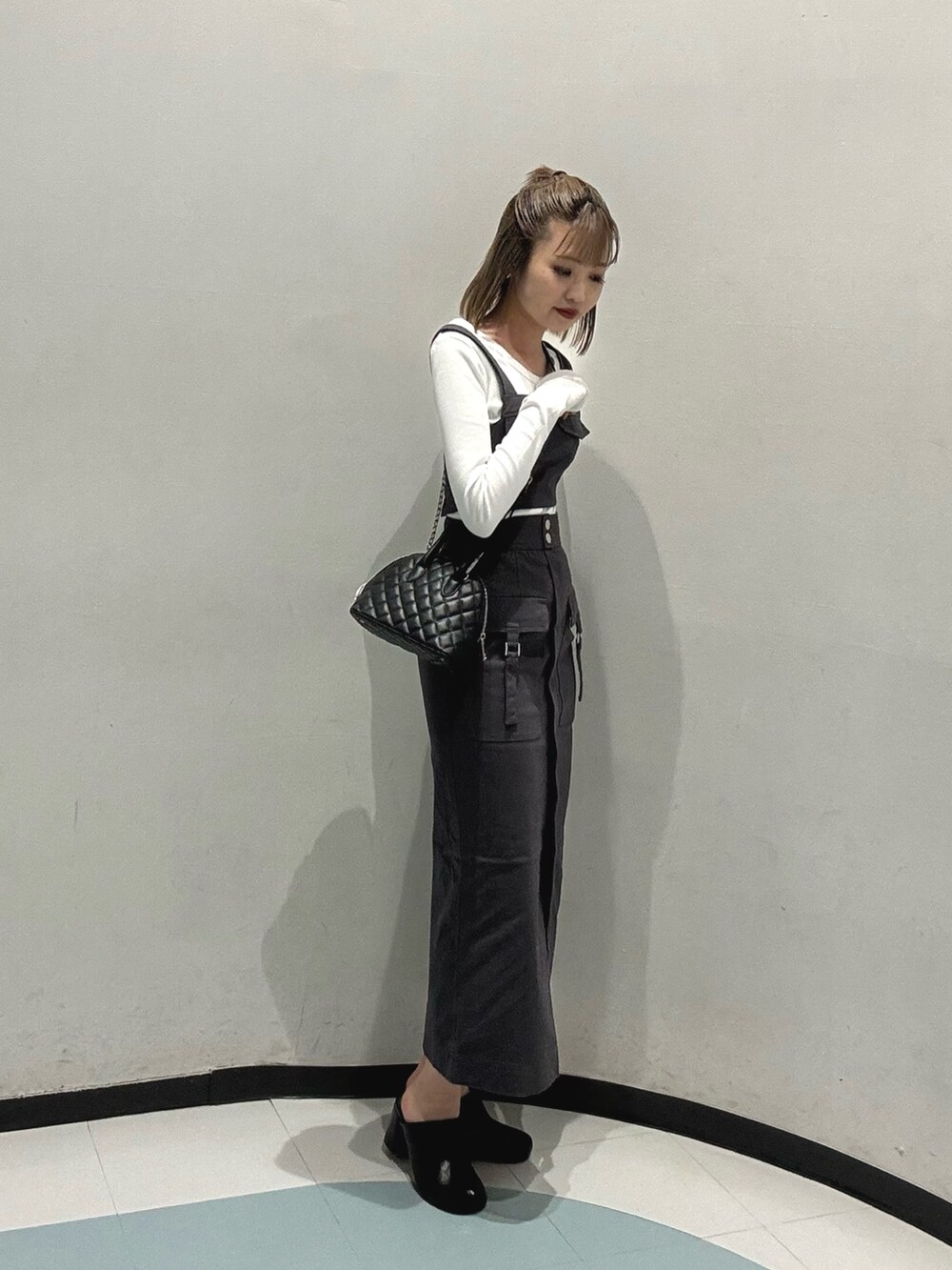 ホワイト系のTシャツ/カットソー、グレー系のワンピース、ブラック系のサンダルを着用したレディースの冬コーディネートの2枚目の写真