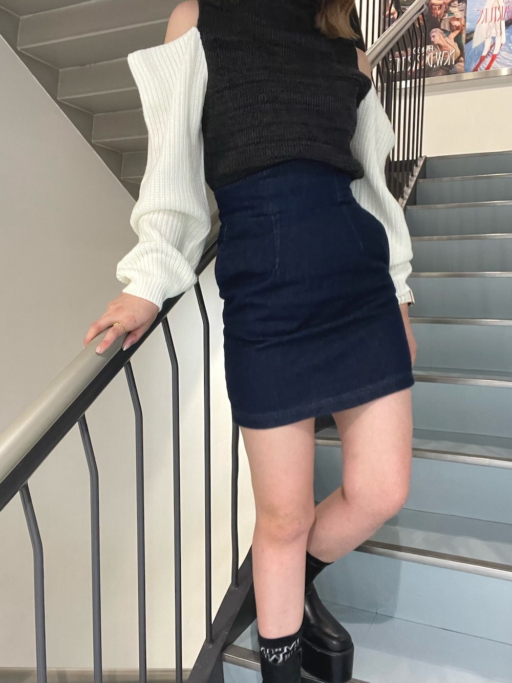 ブラック系のボストンバッグ、ブラック系のニット/セーター、ブラック系のブーツを着用したレディースの秋コーディネートの5枚目の写真