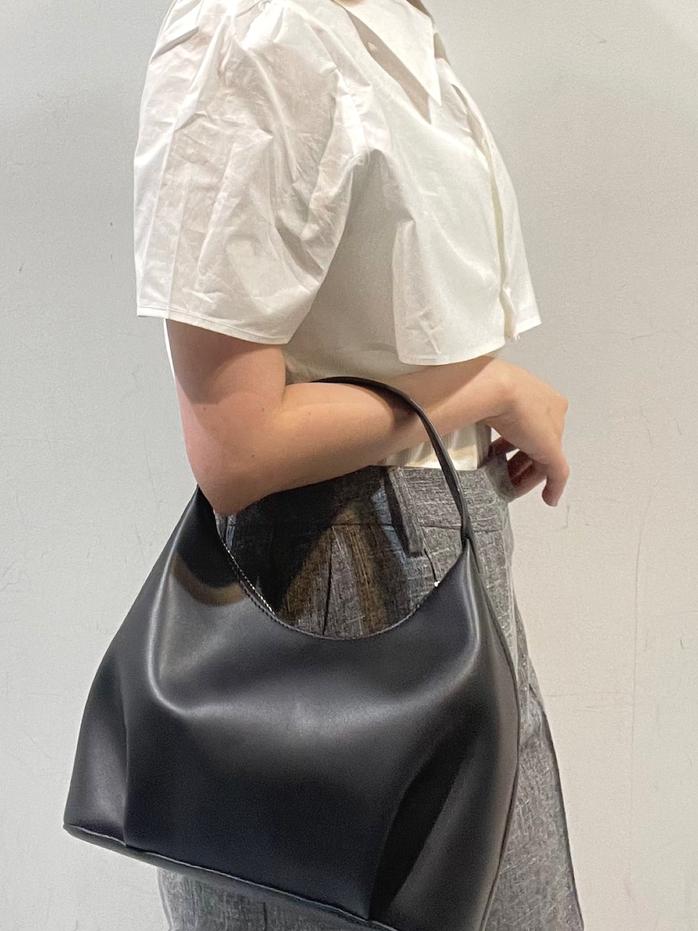 ブラック系のハンドバッグ、ホワイト系のシャツ/ブラウス、ホワイト系のサンダルを着用したレディースの春コーディネートの6枚目の写真